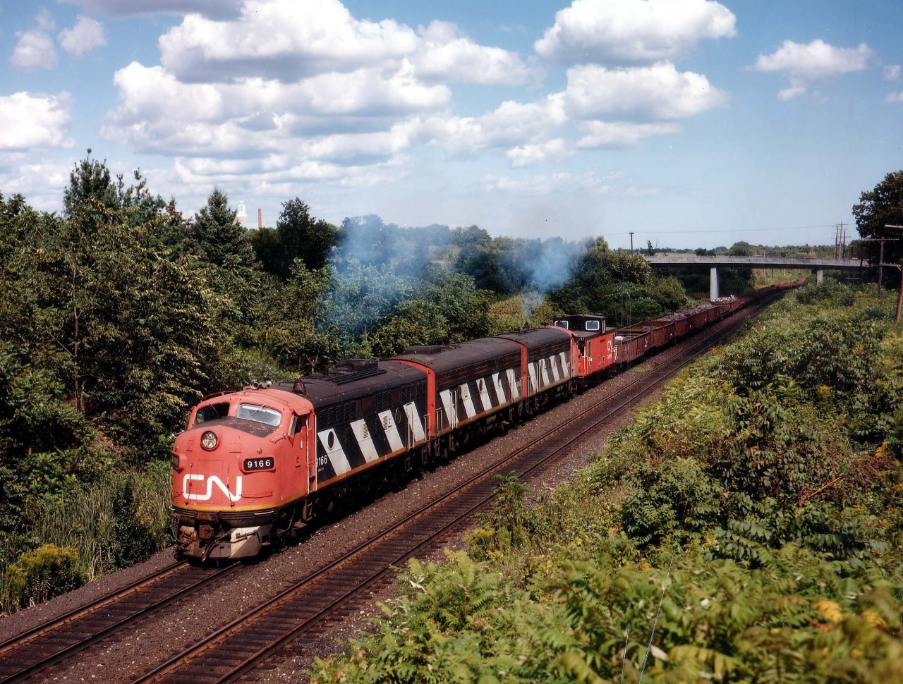 The CN version of the Nanticoke Steel Train, in this image on the move from Hamilton to the affiliated steel mill in Nanticoke by way of Brantford and south was very short lived running with this A-B-A lashup. There always seemed to be some mechanical problem and it wasn't long before GP9s were in the mix and after that, the GP40 Widecabs took over, making this, in the hearts of the fans, just another train heading west............
Seen here approaching Mile 1 Dundas sub are CN 9166, 9195 and 9177. The bridge in the background supports Old Guelph Rd.  Winning "a fight with the cloud" was nice. :o)