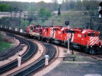 [Editors note: Despite quality issues - content has been deemed appopriate] CP 5914 and 5911 are but 5 months old as witnessed in this May 13, 1979 view of the TH&B "Starlite" rolling Hamilton-bound thru the junction at Bayview. Other locomotives are CP 8751, TH&B 56 and a CP 81xx trailing. One has to express curiosity as to why railfans would wear almost white !!! clothes when out amongst the grease and the grime of the railway landscapes........and indeed why they are chancing the location that they are. Times and styles have changed. Railfans used to have the run of many locations without interference from authority. All this has a thing of the past, but many fans have not changed along with it. (How many have ever been hurt or killed while railfanning, would be an interesting statistic)Incidentally, the rusted track on the left is from the days when steam engines waited to assist westbound trains up the Dundas grade, a hold-over only because in the 1970s MoW equipment used this stub. The track has long since been removed.