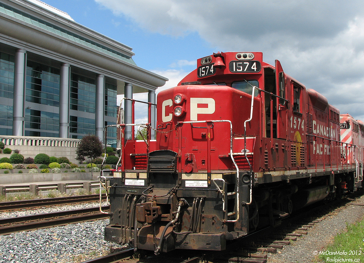 Working a cut of grain hoppers across from the modern-esque 1990's-built Ontario Government Building on Red Rock Road, CP GP9u's 1576 and 1571 idle along the fenced-off platforms of the former CNR Port Arthur Station. At the time the station, across from the Thunder Bay Marina, was converted to a multi-use facility that included an ice cream parlour and space for the Thunder Bay Model RR Association, among other tenants. And, a restored wooden CNR caboose also graced the grounds nearby.