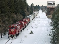 I'm posting this shot to show a more contemporary view from the Hwy 35 bridge at Pontypool. Almost 27 years after S Danko's view of VIA 189 flying through town, CP 3105, 3045, 8200, and 3042 plod through at 10mph with T07's train. The siding, obscured by snow, remains, though it is now stub ended with the wheelstops located at the bush below the crossbuck. The elevator still stands, and indeed is seeing a slow restoration by locals, though the office section seen in the earlier shot is now but a crumbling foundation. The trees have grown much in the intervening years. And the railroad runs a few round trips to Toronto per week, under the guise of the Kawartha Lakes Railway internal shortline, at a relaxed pace, down from six per week in the eighties. 0910hrs.