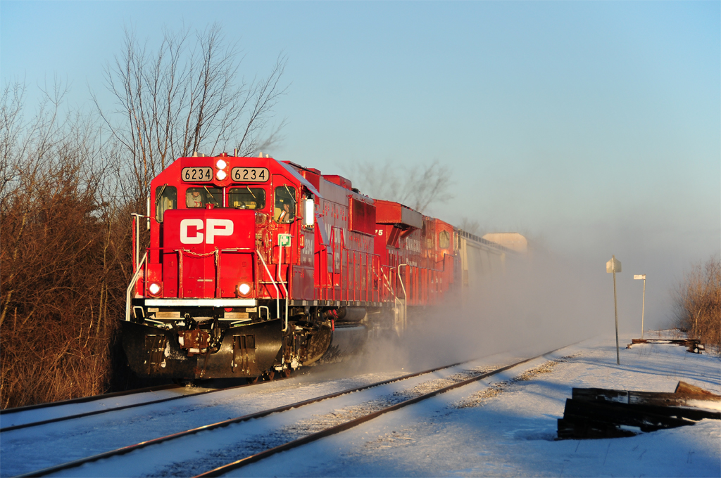 By a windy day, CP 233 with an ex-SOO Line engine in lead, is horning in the small town of Green Valley.