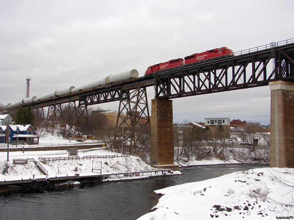 CP 6240 South with train DIM-006 consisting on 35 W10 dimensional load's in the form of windmill tower parts loaded onto 50 TTYX flats, flying over the town in Parry Sound late in the evening light. When they happen, these W10 dimensional moves aren't authorized to run across CN's Bala sub per DRZ agreement, providing a rare opportunity to grab a Southbound running down CP's Parry Sound sub, just like old days!