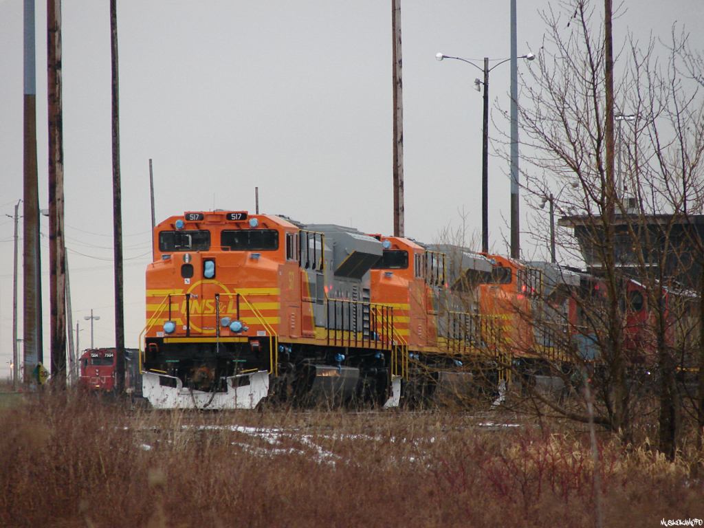 Brand new and fresh from Mexico, QNSL SD70ACe's 517, 516 and 514 sit outside the shops at CN's MacMillan yard, waiting for the shop switcher to return and run them around the horn to the other side of the shop area to join 7 more QNSL SD70ACe's all heading Eastwards together. Photo taken from city, not private property.