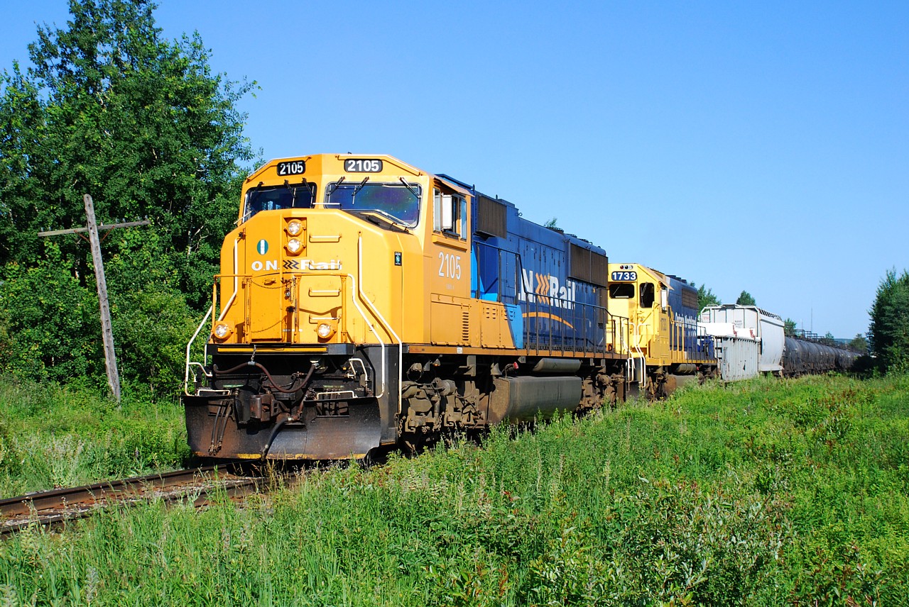 Ontario Northland train 214 throttles up departing Englehart in to the brilliant morning sunshine.