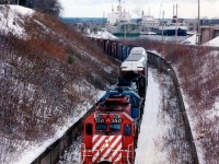 It was indeed a surprise when, waiting for NS #328 autoparts train at Merritton, to witness them stop and the switch  thrown at mile 9.49 and the train lined for the Thorold sub. What the???? Emergency work of some description was to be performed on the CN Canal bridge 6 and that #328 was to detour down the Thorold Sub and across brige 10 to CN Allanburg and onto the Stamford at Port Robinson. With two ships in the Twin Flight Locks, it made for a unique opportunity to catch trains and boats in the same photo. Power was nice as well, CP 5521, GATX 7371 and NS 6215. I was to witness moves like this a couple more times in the next few weeks. The Thorold bridge 10 was dismantled in 1997 and thus the east side of the line is now CN Thorold Spur and the west side (pictured) is the PCHR (Trillium) Canal Line.