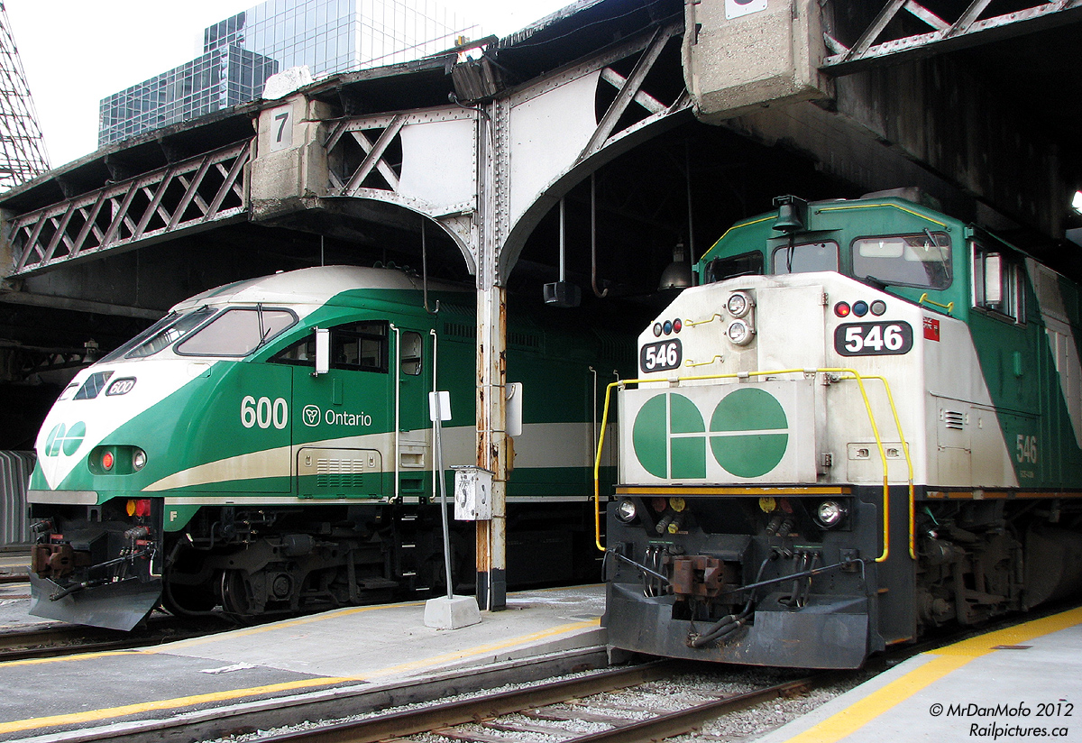Back when the MPI MP40PH-3C units were still pretty brand new, the crowded Milton line was the first to get longer 12-car trains (due to GO not being able to run more Milton trains at the time, they instead ran longer ones, 10 vs 12 cars). 6-month old class unit GO 600 sits on the tail end of Milton train #159, poking its head out of the trainshed on Track 7 alongside the photographer's Barrie-line train #809 on Track 6, with older F59PH 546 trailing this evening.

Another interesting detail: the TTR (Toronto Terminals Railway) logo on the wooden phonebox, attached to one of the support beams of the 1920/30's era Bush train shed between the locomotives.