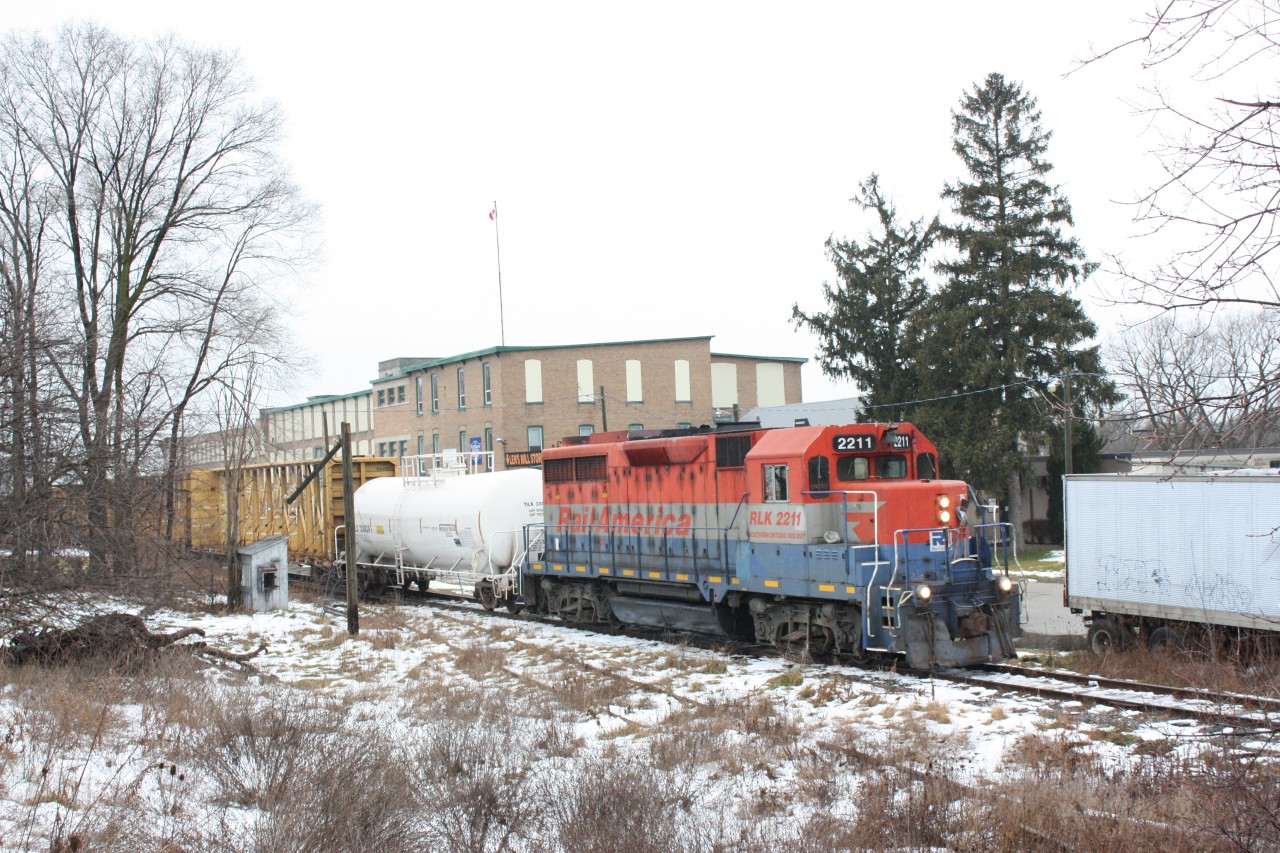 SOR GP35 #2211 rolls past the old Lens Mills factory at Hespeler on its way back to Guelph. The cut off track in the foreground was once part of the Grand River RR (CP).
