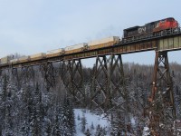 Not to many people know about this bridge; the Little Jackfish River trestle on the Caramat Sub north of Lake Nipigon. In 1942 the Canadian/American governments built a water diversion for the Ogoki River/Resevior to feed Niagara Falls and other hydro electric dams. Lots of blasting took place under the bridge for the water flow. Here, train 112 makes the trek across enroute from Vancouver to Toronto