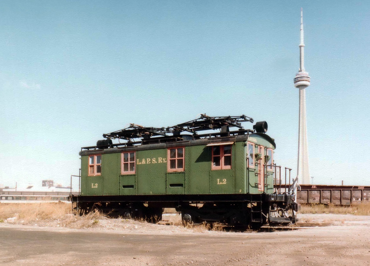 An old London & Port Stanley electric motor #L2 sat for many years on a lonely spur down near the Toronto waterfront. I cannot remember exactly where, as the spur I believe has been removed for quite some time. The motor was purchased by a private individual and moved in 1993 to Brampton. It was subsequently relocated to the Halton County Radial Museum at Rockwood, ON in 1997 and remains there as part of their collection.  In the view looking North toward the CN Tower one might ask "Where is the City"??  Well, it IS back there........somewhere.