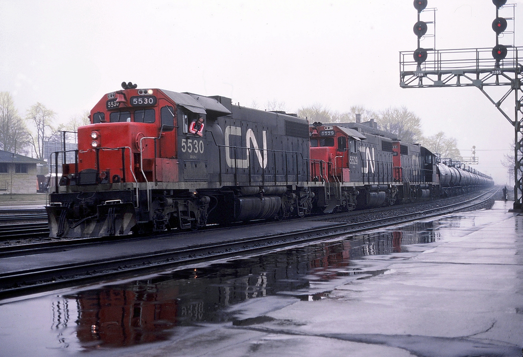 CN 715 is passing the east end of the Brantford Yard with a loaded sulfuric acid unit train @ 11:14 with CN 5530 - CN 5529 - CN 5516 and 36 tank cars with CN van 79278 on the tail end.
