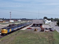 VIA #1 preforms their station stop at Portage La Prairie with an A-B-B-B providing the horsepower, in the background a CP westbound rolls through town towards the diamond.