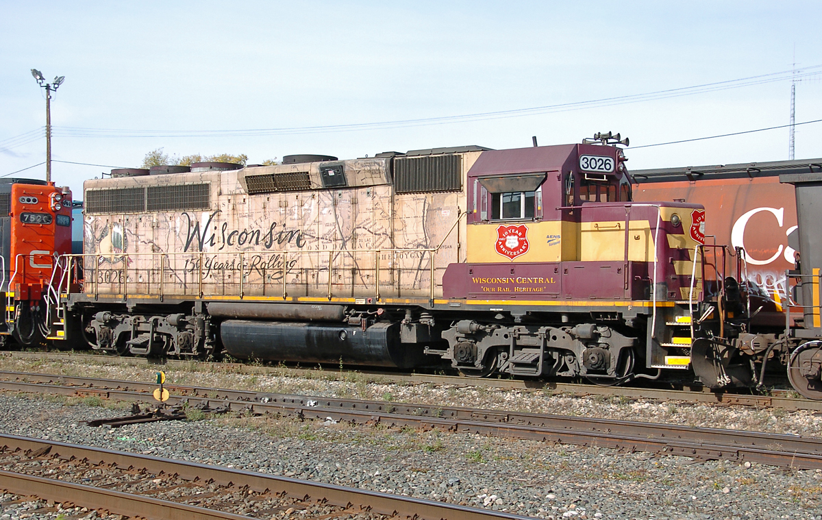 CN GP38-2 7520 and WC GP40-2R 3026 switch a train with some wind turbine blades in the west end of Walker yard. WC 3026 is rare both in being one of two WC GP40-2Rs, but also since it has a one of a kind paint scheme which is a map of Wisconsin and celebrates the state's 150th anniversary in 1998. Rumor has it that this unit and sister 3027 are up for a fresh coat of CN paint soon.