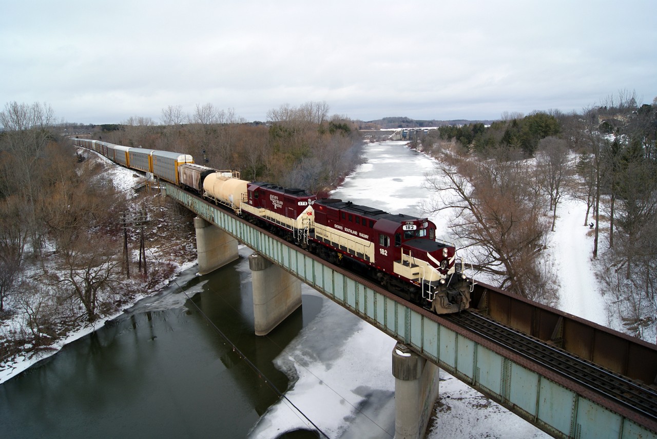 The chill of February shows. There is ice on the Thames River as the Ontario Southland Railway Woodstock Turn pulls its cut out of the siding at Coakley for its return to Ingersoll.