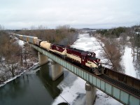 The chill of February shows. There is ice on the Thames River as the Ontario Southland Railway Woodstock Turn pulls its cut out of the siding at Coakley for its return to Ingersoll.