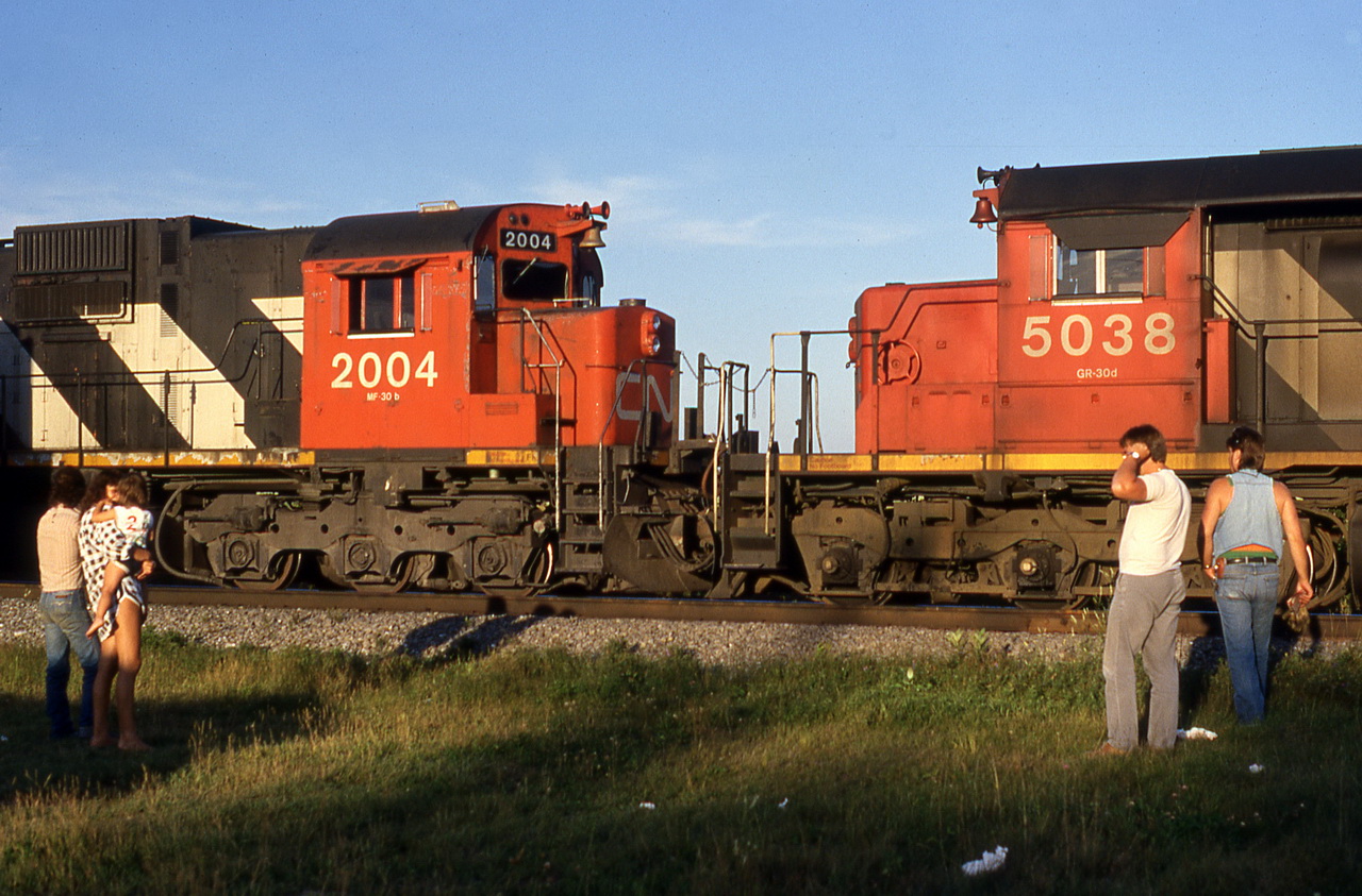 CN 207 waits for VIA 24 while the engineer and the head end brakeman and some spectators watch.