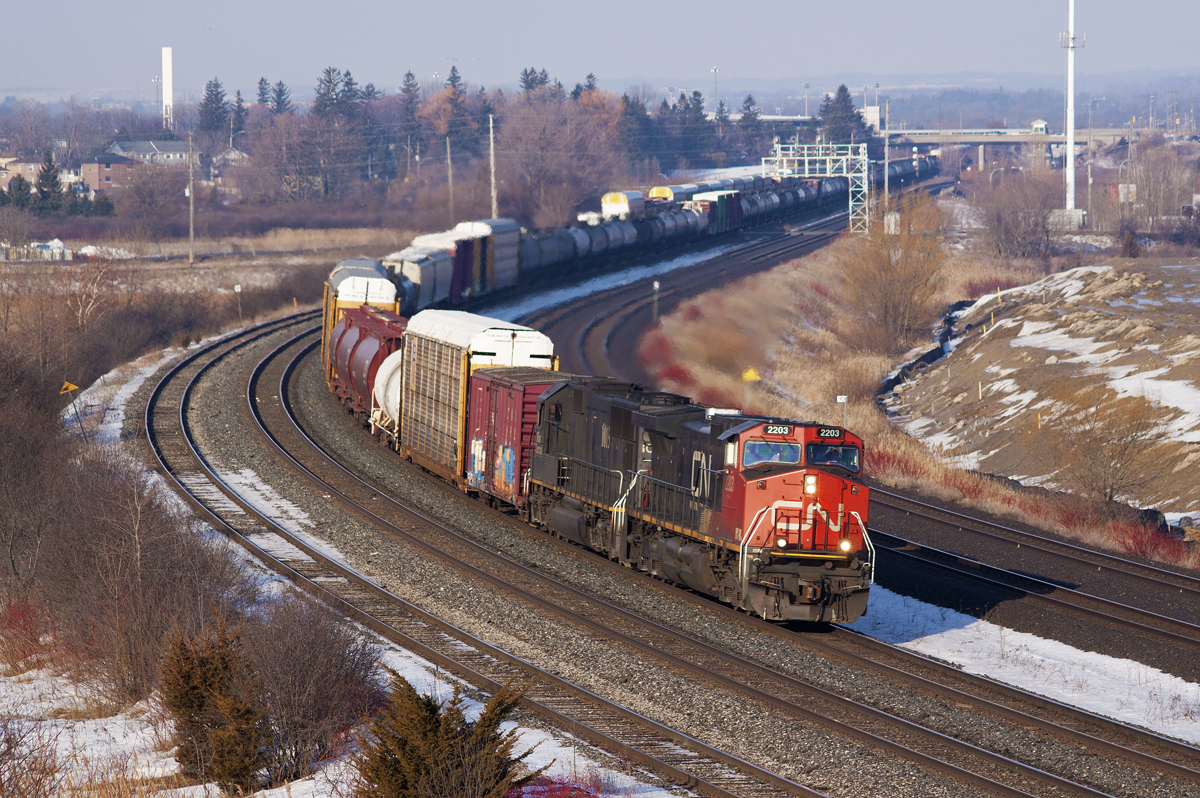 CN M30831 26 rounds the bend in front of Gerdau Steel. This scene is rapidly changing with the construction of GO's new maintenance facility north of the tracks. The train in the background is the tail end of CN M37321 26, which I would later catch at Pickering Jct due to a broken air hose.