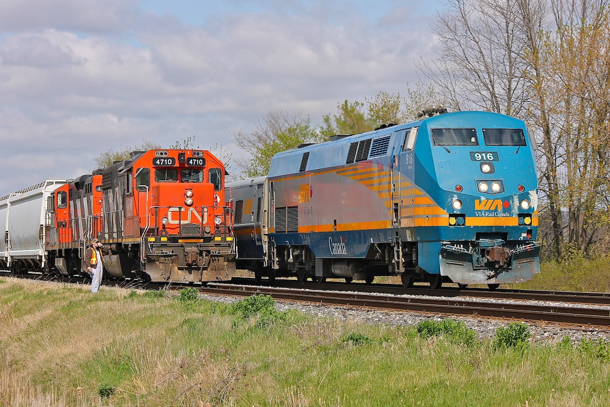 Captured here is a scene that is always a favourite of mine, VIA 73 rolls passed CN 439 on the approach to Chatham East as the engineer sips on his coffee taking advantage of the nice springtime breeze looking on as the flashy passenger train scoots by.

Refer to Stephen Host's photo of 4701 at Aldershot for an interesting comparison of two very different looking units in the same class by clicking the link here http://www.railpictures.ca/?attachment_id=8202 .