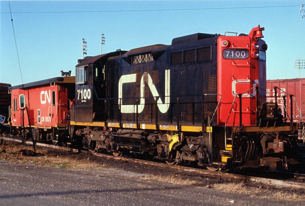 The first of the "Sweeps", CN #7100 sits awaiting next assignment in the diminutive yard off the Grimsby sub at mile 9.49. These unusual appearing locomotives are actually an SW1200RS switcher in a GP 9 shell, remanufactured with GP main generators, cooling fans and other such parts mated with the SWs, resulting in a model known as SW1200RM. The production took place at Pointe St. Charles main shops in the mid-'80s, and the units were sold off to CANAC in 2000. Seeing only eight (7100-7107) of these creatures were created, this was a rather rare bird.