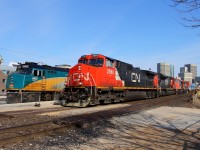 CN's Q111 passes Union Station with the westbound "Canadian" sitting in the shed.