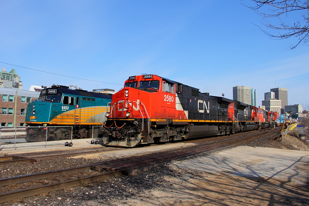 CN's Q111 passes Union Station with the westbound "Canadian" sitting in the shed.