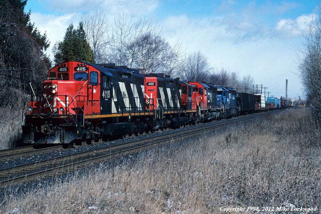 I wasn't foaming this day, but for whatever reason had the scanner on and heard that train 335 (Garneau, PQ. to Buffalo, NY) had stalled on the 'Scarborough Hill'. It took a little while to get down to the tracks, but when I did was greeted with a unusual sight in the diesel era; headend helpers. Though helpers were most common here in the steam era from Don Yards as far as Port Union, a combination of better low speed pulling power of the diesel and the re-routing of most freights away from downtown via the York and Halton Subs had made this non-existant. Usually a heavy train with a good amout of steel out of Hawkesbury, it would seem that this 335 was too much for CN 6027 and CR 6666 to get over the hump, so 546's power, CN 4115 and 4101, came to the rescue. And yes, it sounded great! 1329hrs.