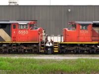 Nose-to-nose, a pair of stored CN GM units sits at the side of the MacMillan Yard Diesel Shop. CN 5553, an SD60F, displays the full-width "Draper taper" behind the cab. 5326, an SD40-2W, only has the "Canadian Safety Cab" with a regular SD hood. Note the minor differences: side cab access doors on the SD60F, numberboard locations, frame height/wheel size, bell bracket, different pilot steps, side cab windows, and wheel bearings to name a few.
<br><br>
* Photo taken from adjacent lot to rail property.