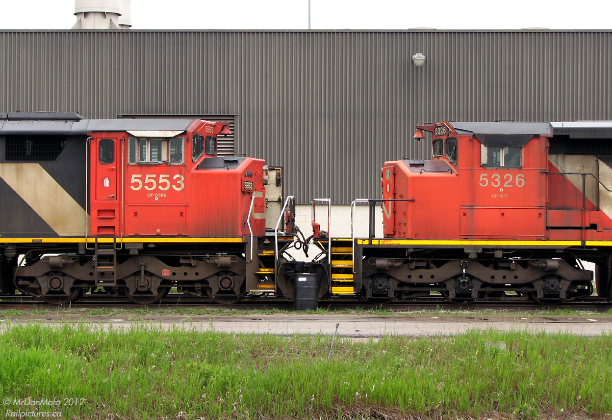 Nose-to-nose, a pair of stored CN GM units sits at the side of the MacMillan Yard Diesel Shop. CN 5553, an SD60F, displays the full-width "Draper taper" behind the cab. 5326, an SD40-2W, only has the "Canadian Safety Cab" with a regular SD hood. Note the minor differences: side cab access doors on the SD60F, numberboard locations, frame height/wheel size, bell bracket, different pilot steps, side cab windows, and wheel bearings to name a few.

* Photo taken from adjacent lot to rail property.