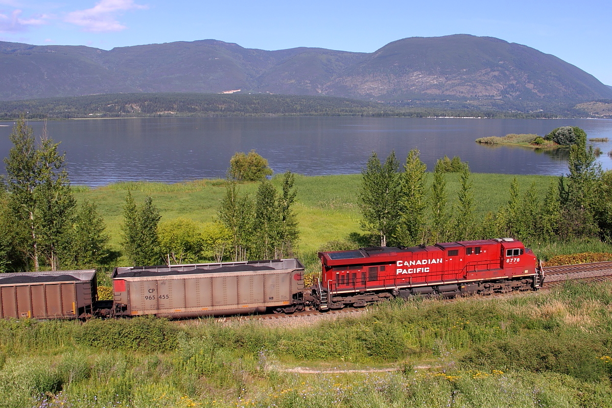 CP 8778 pushes hard on the rear of this coal train as it skirts along the shore of Shuswap Lake in Salmon Arm.