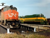 The CN 'table at London, Ont. CN 2101 (BBD HR616) is being manoeuvred as DEVCO 226 and 227, new from GMD,  await shipment to Cape Breton Development Corp.  CN 2101 had been sold to Bombardier in Feb 1982 who in turn sent it to CP to demo as their 7002. It reverted back to its CN roots in May 1985 and worked until retirement in 1998. DEVCO existed from 1968 to 2001 when it became Sydney Coal Railway. The 226 and 227 were part of a GP38-s order that had the ability to be used as emergency power generators at various Cape Breton DEVCO mines. The DVR 226 is now SCR 217 and the 227 was sold to Connell Leasing in 1998. It currently is #2014 on Central Michigan Rwy.  I have forgotten the exact location of the London 'table and would appreciate correction.