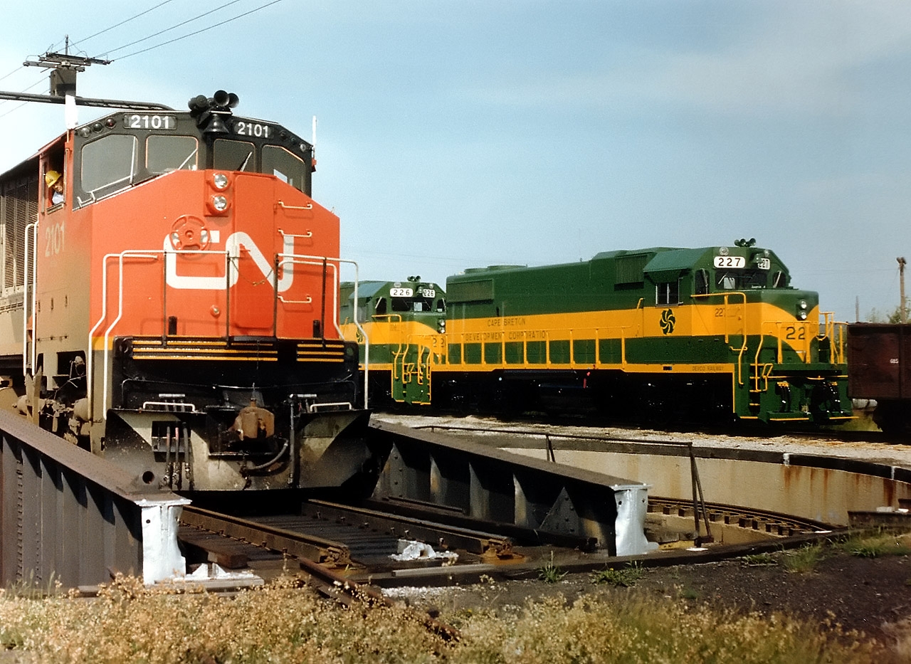 The CN 'table at London, Ont. CN 2101 (BBD HR616) is being manoeuvred as DEVCO 226 and 227, new from GMD,  await shipment to Cape Breton Development Corp.  CN 2101 had been sold to Bombardier in Feb 1982 who in turn sent it to CP to demo as their 7002. It reverted back to its CN roots in May 1985 and worked until retirement in 1998. DEVCO existed from 1968 to 2001 when it became Sydney Coal Railway. The 226 and 227 were part of a GP38-s order that had the ability to be used as emergency power generators at various Cape Breton DEVCO mines. The DVR 226 is now SCR 217 and the 227 was sold to Connell Leasing in 1998. It currently is #2014 on Central Michigan Rwy.  I have forgotten the exact location of the London 'table and would appreciate correction.