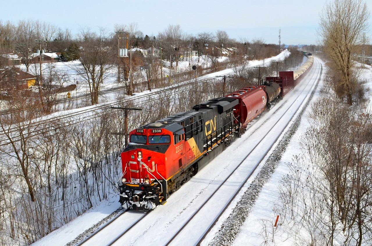 CN 2338 is seen leading a westbound through Beaconsfield on a crisp but clear winter day, with CN 2673 about halfway back as the DPU.
