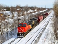 CN 2338 is seen leading a westbound through Beaconsfield on a crisp but clear winter day, with CN 2673 about halfway back as the DPU. 