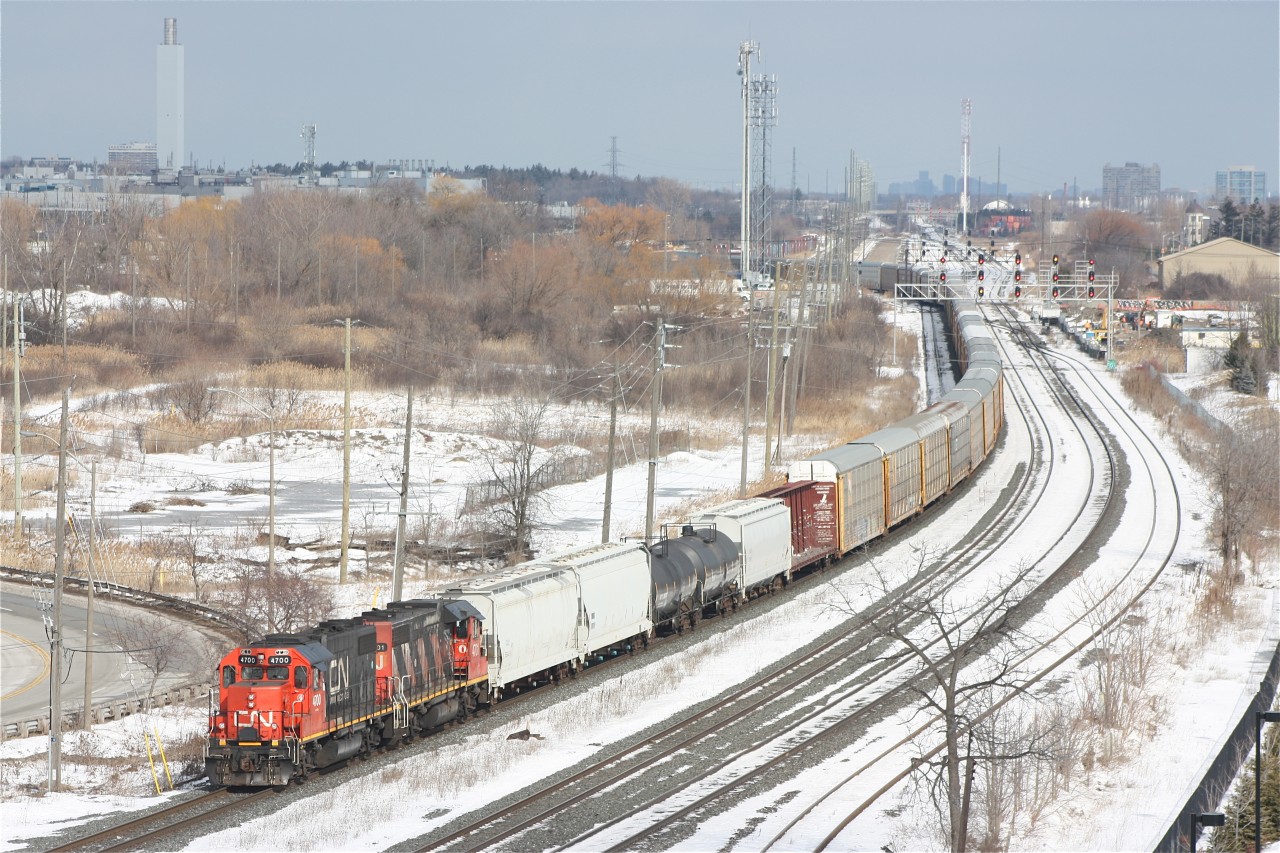 A CN Oakville to Aldershot transfer job is about to pass the new GO Transit parking garage at Oakville's GO/VIA station.