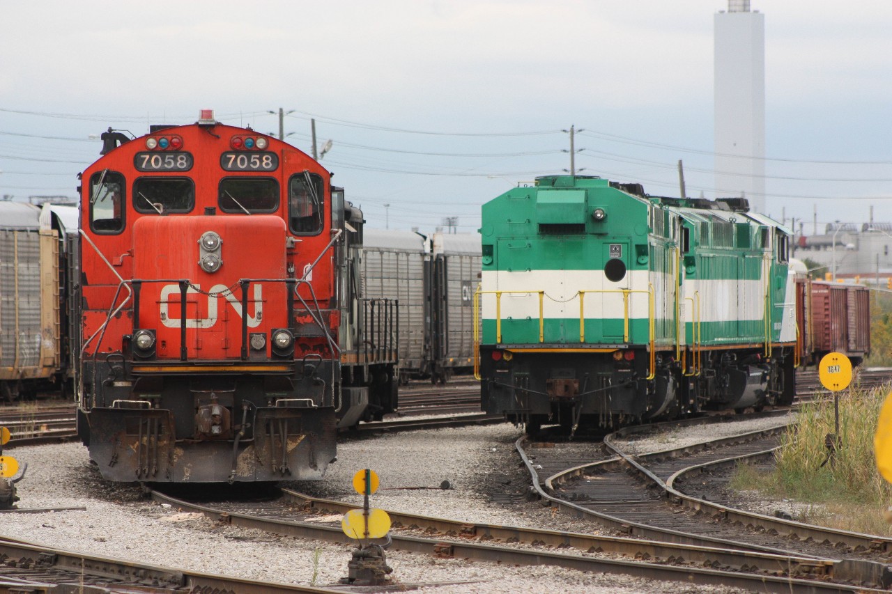 A pair of former GO F59PH sit along side a CN GP9RM while awaiting shipping out to their new owner