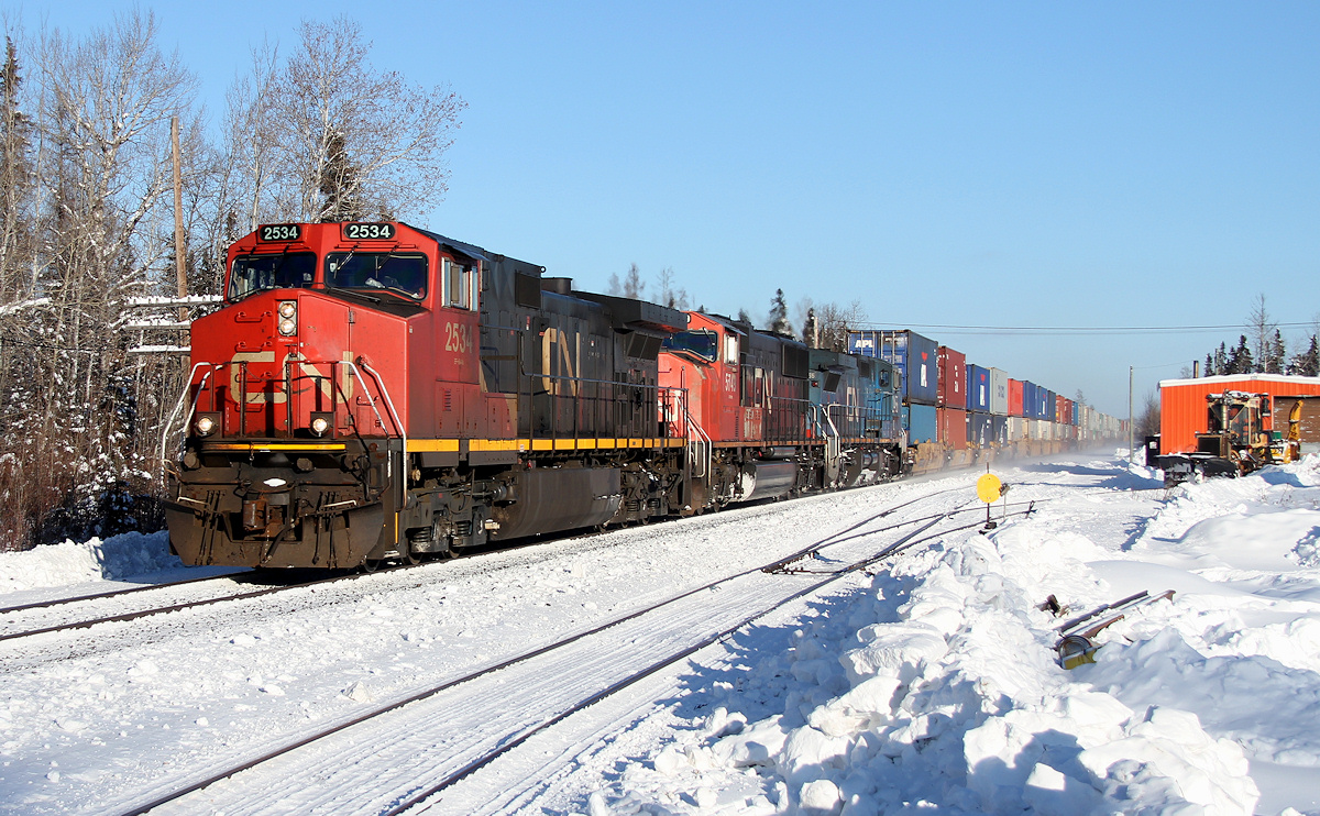 CN train 107 glides through Auden, ON with Montreal-Toronto-Winnipeg stacks. The machine I operate is tucked away in the Auden spur.
