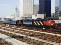 On a nice warm spring morning, April 10, 1977, the CN Rapido is pulling away from Toronto's Union Station beginning its trip eastward. Power is CN 6542, VIA 6627 and CN 3107 with a lengthy train in tow. Although the VIA system has not yet officially come into being, a lot of cars and the B unit are already sporting what is now such a very familiar paint scheme. Note the O'Keefe Centre and a very visible Royal York Hotel in the background.