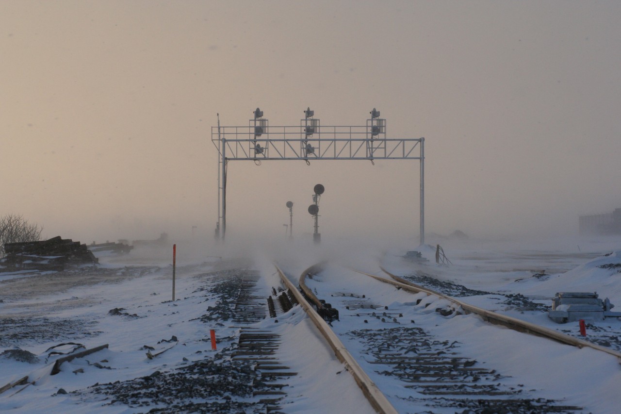 On a cold, snowy New Year's Eve day, the former searchlight signals guarding the east siding switch of Wolverton siding on the Galt Sub are dwarfed by the brand-new signal bridge guarding what is now "East Begin/End CTC Sign Wolverton (WOL)." Can someone comment on the positioning of the searchlights. Older pictures revealed that the double signals were closer to the road behind me.