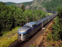 VIA 6424 with train 1, The Canadian, passes the Schreiber mile board at mile 117 on the CP's Heron Bay Sub July 24, 1989.