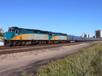VIA's westbound "Canadian" departs Winnipeg's Union Station, CN intermodal Q199 can be seen on the far right following.