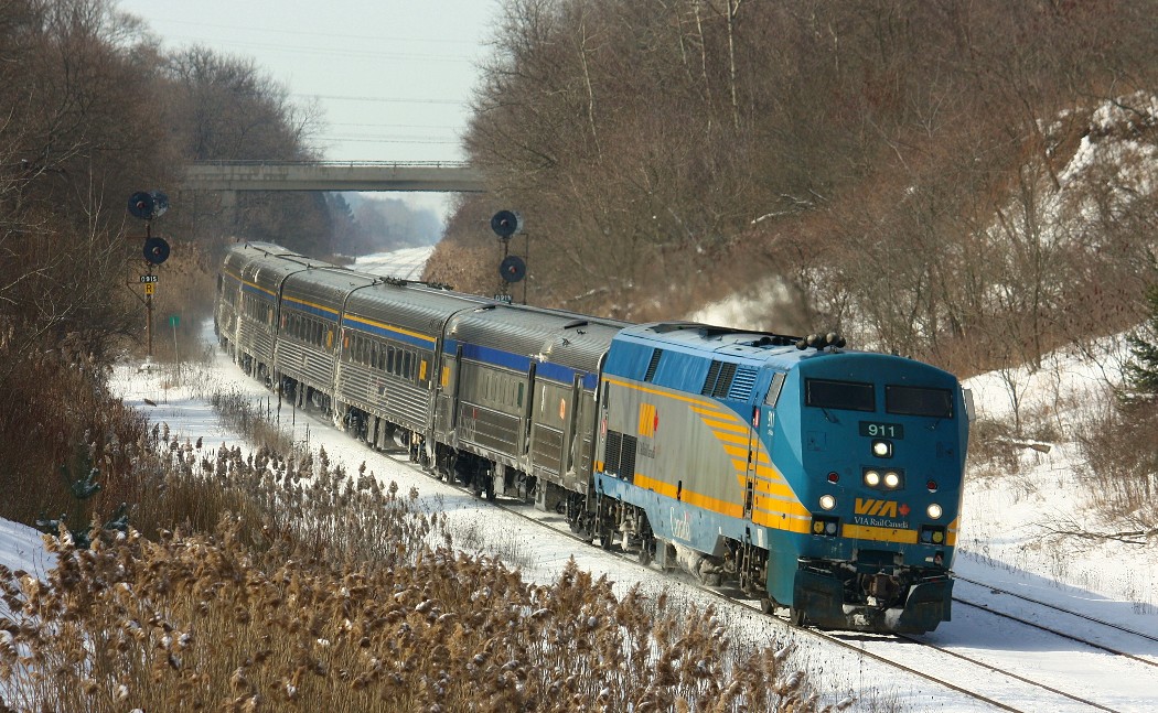 Via 911 was rolling slowly through the first curve at Copetown towards or starting down the Dundas hill. On this day, my father and I went to the Copetown train show a short distance from the tracks. When we arrived, we heart a horn and decided to wait and see what would show up. 148 then appeared going down the grade, consisting of solid intermodal. Then 148 spoke to 383, who was a short distance away. 148 reported a man walking along the tracks a short distance away, so we knew he was close. We then heard the distinctive sound of a GE coming up the hill. We got there just in time to see CN 2635, IC 1018 and CN 5761 pulling hard against aprox. 124 cars.