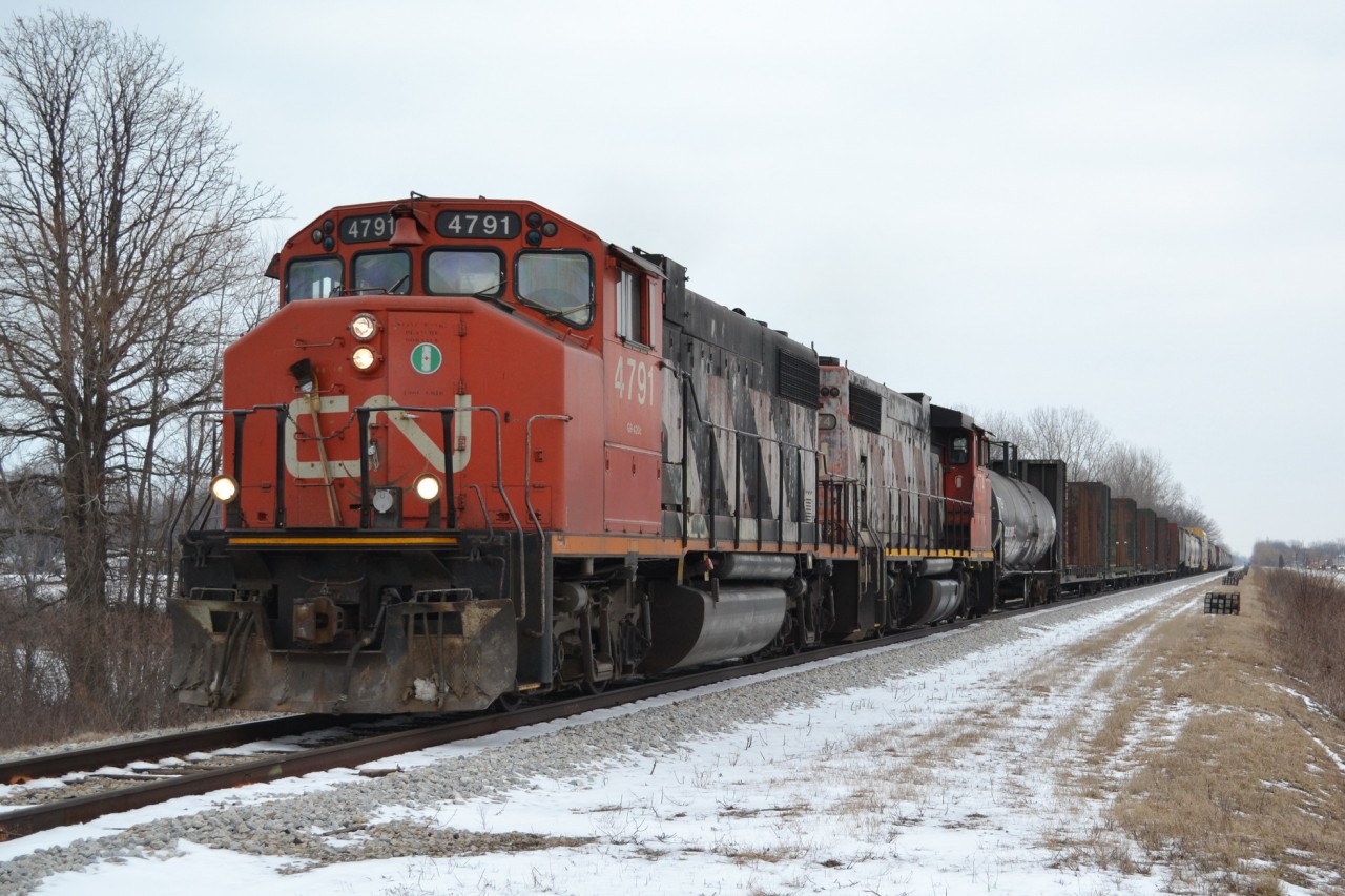 CN 439, with CN 4791 & 4774, and about 30 cars, heads down the VIA Rail Chatham Sub, at Wallace Line. You can see the Ties lined up along the side of the mainline for a Tie project that started late in 2012 and was put on hold for the Winter, and will start up in the Spring time. At this location, Freights can go 60 MPH, and Passenger trains can go 90 and LRC Speeds is 100 mph...