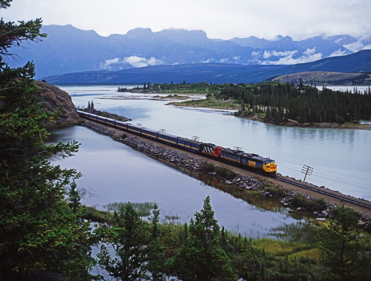 VIA train 3, the westbound Super Continental, on a rainy day running along Jasper Lake.