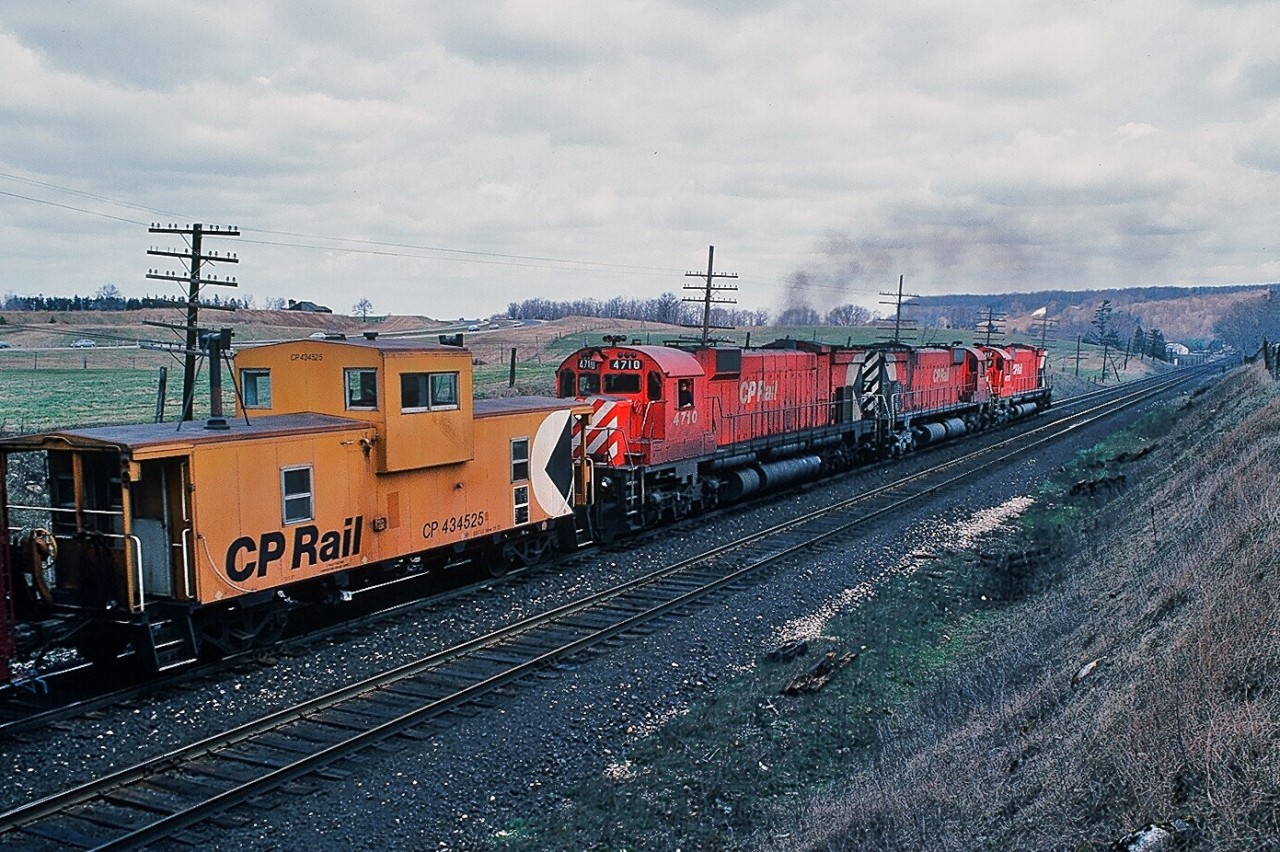 M for Magnificent.


On a cool, breezy and mainly cloudy early April 1980 Saturday a typical uninteresting Galt Subdivison afternoon, developed into an Alcophile's delight.


On the approach to Campbellville - on the grade up the Escarpment - CP Rail extra 4723 west ( with 4550 ) stalled when #4723 shut down. With 4723's train blocking  level crossings and with CP 4710 west following closely, extra 4723 west was unable to double the hill. ( At this time it was ABS territory, CTC to be installed at a later date ). Westbound 4710 ( with 4727 – 4717 ) crew cut off their train – near Hornby – running light to extra 4723 west's caboose ( #434525 ), coupled on and after some radio chatter commenced pushing extra 4723 west up the hill through Campbellville onto Guelph Junction. Second shot in the sequence of four, near Canyon Road. April 1980 Kodachrome by S.Danko.


 More big M's  at work :


  at Campbellville