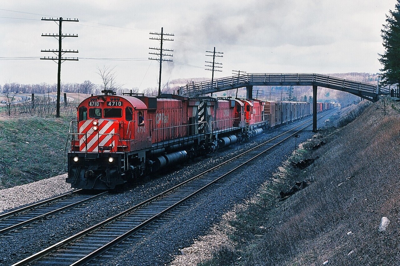 M for Magnificent.  CP Rail 4710 west has its own train in tow as it storms the hill up to Guelph Junction. The 4710 - 4727 – 4717 M636 trio completes the third pass of this day after providing Push Service for Extra CP Rail 4737 west. Fourth shot in the sequence of four, near Canyon Road. April 1980 Kodachrome by S.Danko.

 Big MLW 's  at work :


  extra 4723 west  


  the big M pushers  


  more big M pushers  


 the biggest big M