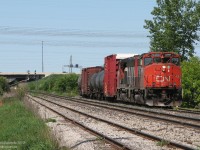 <b><i>Like shooting fish in a barrel.</b></i><br><br>After running out of batteries standing trackside just as CN #577 departed Malport Yard (about a kilometre up the road), I quickly swapped in some new ones and zipped down Torbram Road to catch them at the crossing just to the south. A pair of CN GP40-2L(W) units, rare to find on the mainline but the soup du jour of 577, haul their train around the bend from the Halton Sub onto the Weston via the low speed north service track on a hazy spring morning. <br><br>The junction point of Halwest (officially by Hwy 407 on the left in the distance, in Brampton) is the meeting point between the busy Halton Sub mainline from Burlington to Vaughan, and the mostly passenger Weston Sub from Toronto to Brampton (where we are right now was taken just across the city limits in Mississauga). 577 was at the time the regular CN-CP interchange train, taking CP cars to West Toronto/The Junction and CN cars back to MacMillan Yard in Vaughan.