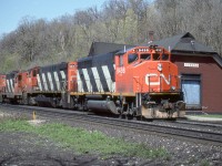 CN GP40-2L(W) 9498 is shown eastbound past the long abandoned Dundas train station in the company of M-420 2515, and GP9’s 4505/4581. Note the ‘extra’ flags on 9498. Sadly, a few months after this photo was taken the ‘Insulbrick’ clad station was torched by vandals and severely damaged. Despite follow up local preservation efforts the station was razed by intentional fire in January of 1988.