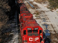 As winter melts away, the siding at Pontypool once again sees daylight, but shall likely remain as disused in the warm weather as it has all winter. At least the mainline still sees a few trains a week, evidenced by the passing of T07 under the watchful eye of the partially restored grain elevator, the new cedar shingles on the west wall gleaming in the low afternoon sun. CP 3057, 3117, 3114, and 8233 lead the way. 1714hrs.