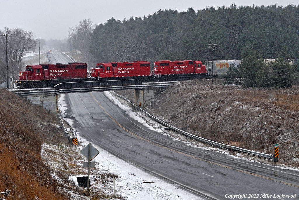 CP 3114, 3103, and 3057 lead KLR T08 over Simcoe Street North at Raglan through a late autumn snowfall. 1016hrs.