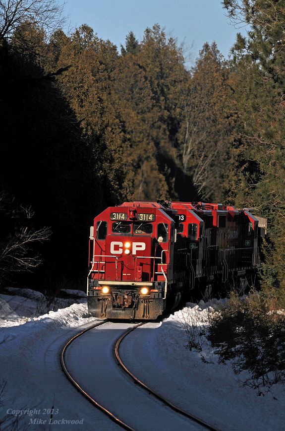 Sunlight streams through a gap in the otherwise heavy tree line, illuminating CP 3114, 3103, and 3134 as they lift T07's 33 cars up Maryanne's Hill. There are at least 29 cars from Unimin on this train, meaning at least 29 loads. Not a big deal on the high iron, however on this line, the combination of grades and a 10mph speed limit means that a little extra is needed to keep them moving forward; no such thing as taking a run at the hill here. 1616hrs.