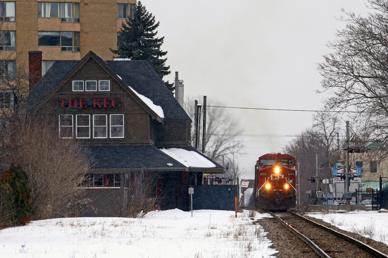 CP 608 accelerates up the short grade from the Thames River bridge onto the Galt sub with CP 9774-CEFX 1045 up front and CP 9350 shoving hard on the rear of the train. The crew had come on duty at Quebec street yard, but the inbound crew had left the train tied down in the siding at Lobo (6.3 miles to the west) the previous night. After running light power to Lobo to retrieve the train, the crew realized they had a bad TGBO, and had to stop at "02" (Begin/End CTC London) to wait for the yard utility to deliver the new paperwork.  The stately CP station is visible at left, now a Keg restaurant. This location was once the original yard location for CP in London, featured a wide passenger platform in front of the station, and was double-tracked up to the bridge in the distance. Things have certainly changed over the years!